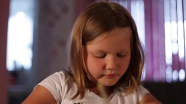 küçük kız sarışın bir kalem çizer.lose-up.arka planda - bulanık pencere