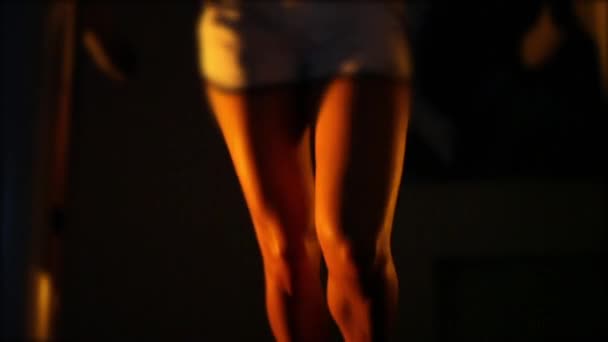 Belas pernas femininas bronzeadas correr em uma esteira no escuro . — Vídeo de Stock