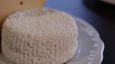 Emmental ve Adygei peyniri ile masaya plaka. kamera etrafında hareket eder. yakın çekim.makro.
