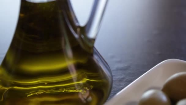 Flasche Olivenöl Und Verschiedene Arten Von Oliven Auf Einem Teller — Stockvideo