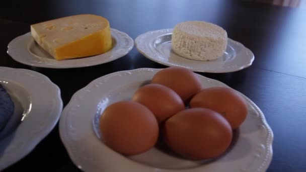 Alimentos ricos en proteínas. carne y pescado crudos, queso, huevos en platos separados. la cámara se mueve alrededor de esto a la izquierda — Vídeos de Stock