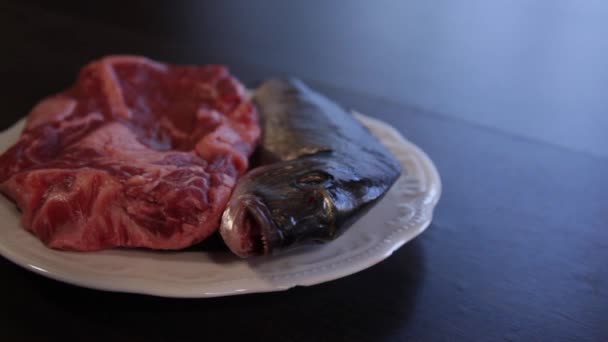 高タンパク質食品。生の肉と魚を皿に盛り付けます。カメラはゆっくりと左に動く — ストック動画