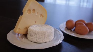 yüksek proteinli gıdalar. ayrı tabaklarda peynir ve yumurta. kamera bunun etrafında niçin sola doğru hareket eder?