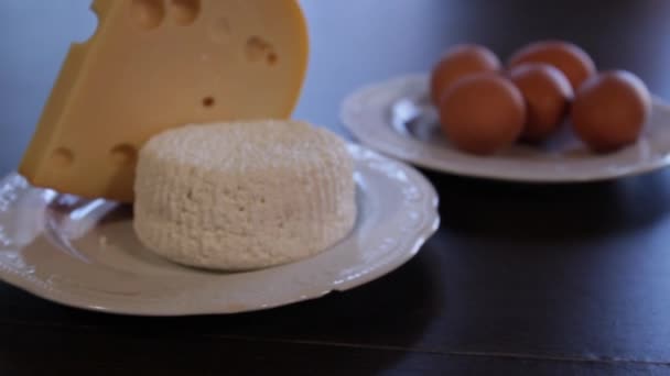 Alimentos ricos en proteínas. queso y huevos en platos separados. la cámara se acerca a ella — Vídeo de stock