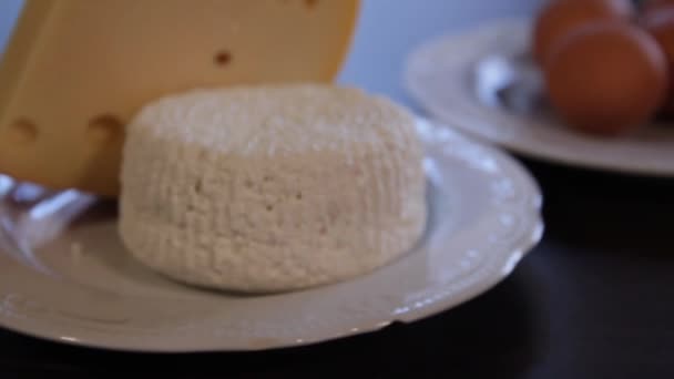 Τροφές υψηλής πρωτεΐνης. τυρί και αυγά σε ξεχωριστές πλάκες. η κάμερα το μεγεθύνει. Γκρο πλαν — Αρχείο Βίντεο
