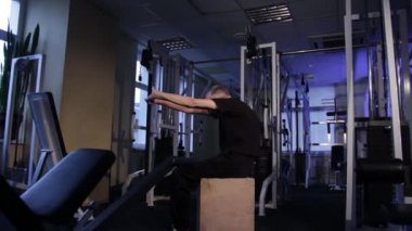 Çağın bir adam dirsek ve geri spor salonunda için ortak jimnastik yapar. Omurilik eğriliği. Kopyalama alanı.