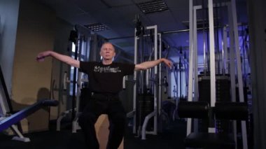 Bu yaştaki bir adam spor salonunda bilek için ortak jimnastik yapar. Kopyalama alanı.