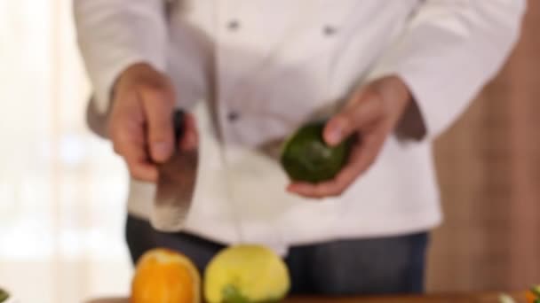 Τα χέρια των μάγειρες καθαρίζουν το αβοκάντο με ένα μαχαίρι. κοντινό — Αρχείο Βίντεο