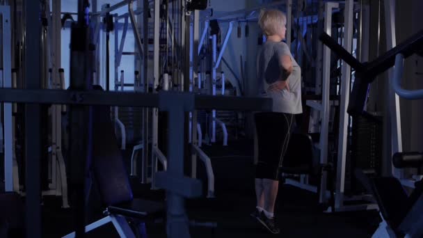 Een oudere vrouw doet een sok lift. gezamenlijke gymnastiek. Kopieer ruimte. zijaanzicht — Stockvideo