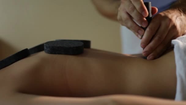 Mujer recibiendo masaje de piedra caliente en el spa salon.Close-up — Vídeos de Stock