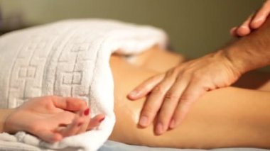 Bir erkek masör spa genç bir kadın bacak masaj. Close