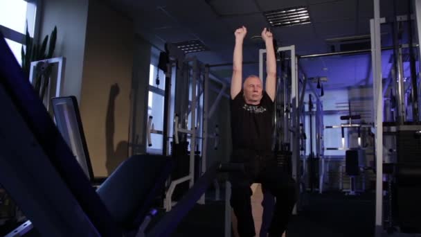 Un hombre de la edad realiza gimnasia articular para los dedos en el gimnasio.Apretar y desabrochar el puño, las manos hacia arriba.Copiar el espacio . — Vídeo de stock