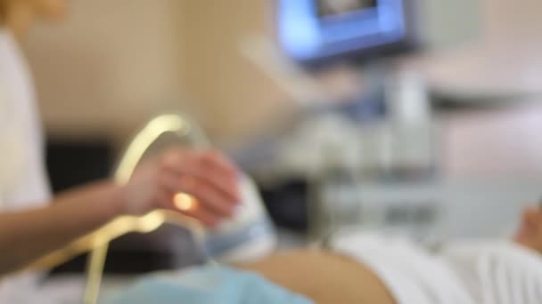 Närbild obstetriska ultraljudsundersökningar. ultraljudsundersökning av en gravid kvinnas mage. Läkare hand — Stockvideo
