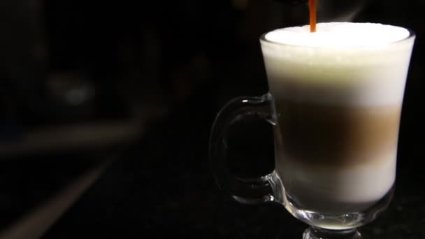 Um jato de café é derramado em um copo de mochaccino ou latte.Blurred background.Copy espaço — Vídeo de Stock