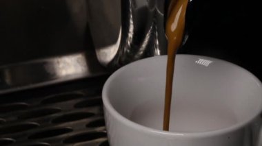 Kahve espresso makinesinden bir fincan içine dökülen kahve jetinin yakın çekimleri
