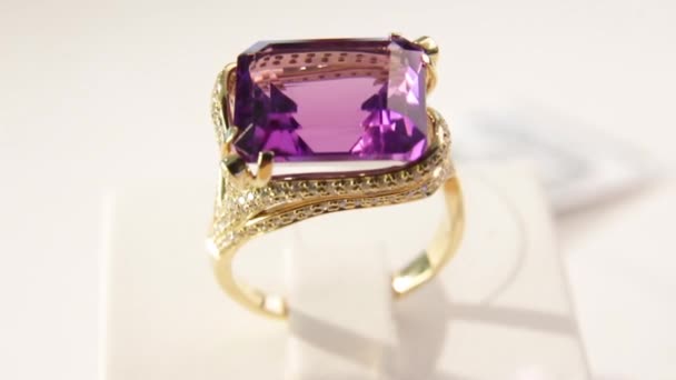 Κοσμήματα, κοντινό κομμάτι χρυσού δακτυλίου με ματζέντα διαμάντι. Ρηχό βάθος πεδίου — Αρχείο Βίντεο