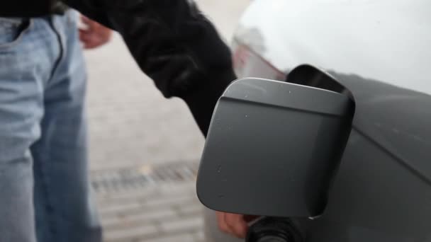 L'uomo tira fuori l'ugello del carburante e chiude il portello del gas, quindi l'auto partire.Distributore di benzina, concetto di prezzi della benzina. — Video Stock