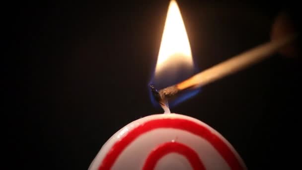 Un primer plano enciende una vela festiva en forma de un número cero, hermosos reflejos alrededor del fuego. Entonces la llama se apaga. Macro — Vídeos de Stock
