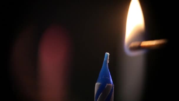 Un fósforo enciende una vela festiva azul, hermosos reflejos alrededor del fuego. Entonces la llama se apaga. Macro — Vídeos de Stock