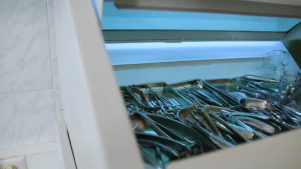 Инструменты стоматолога в стерилизационном шкафу. Удаление зуба — стоковое видео