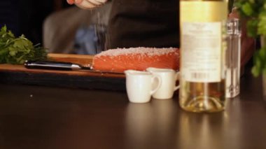 Aşçı kaba tuz çiğ somon fileto büyük bir parça serpilir. Hızlı turşu. Yüksek proteinli gıdalar