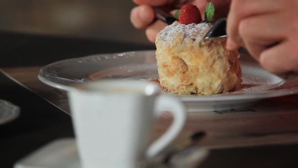 Um homem come sobremesa Millefeuille, decorado com framboesas e hortelã em um prato branco.Napoleão bolo — Vídeo de Stock