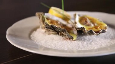 Hollanda soslu pişirilen istiridyeler kaba tuzlu bir tabakta servis edilir. Hollandaise sosu