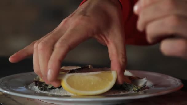 一个男人用柠檬汁倒牡蛎，用胡兰花酱煮熟。荷兰酱 — 图库视频影像