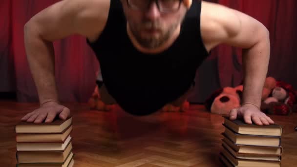 El hombre realiza flexiones usando dos pilas de libros . — Vídeo de stock