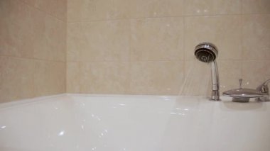 Duş başlığından küvete su dökülüyor..