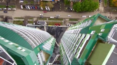 İki yeşil gökdelenin çatısında uçuyor. Yukarıdan bak..