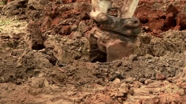 Excavator bucket digs clay and sandy soil. — Stock Video