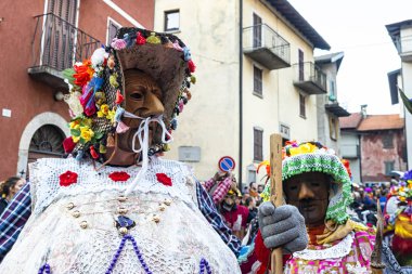Shignano (İtalya) 03/05/2018: Schignano geçit töreni, tipik ahşap maskeleri ve ziyaretçileri eğlendiren sanatçıile Kuzey İtalya'nın en ünlü geleneksel karnavallarından biridir. .