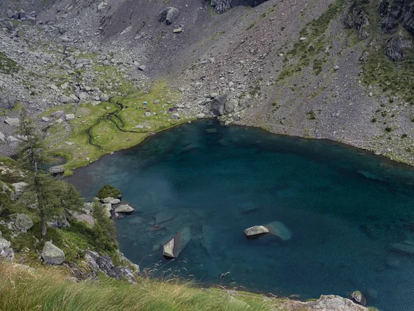 Camping scene next to an alpine lake — Stock Photo, Image