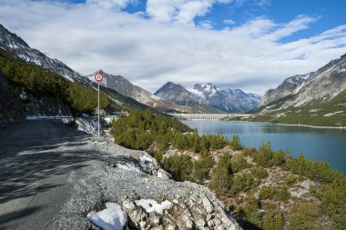 Karlı dağların arka planında mavi suyu olan göl manzarası