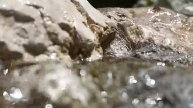 Bir dağ deresinde akan suyun yakın çekimi