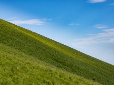 Yeşil bir tepe ve gökyüzü manzarası