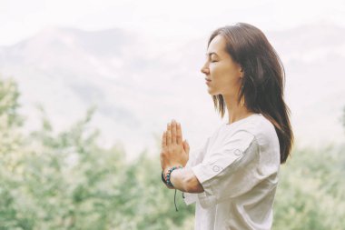 Yoga uygulamak ve yaz aylarında açık kapalı gözlerle meditasyon genç kadın.