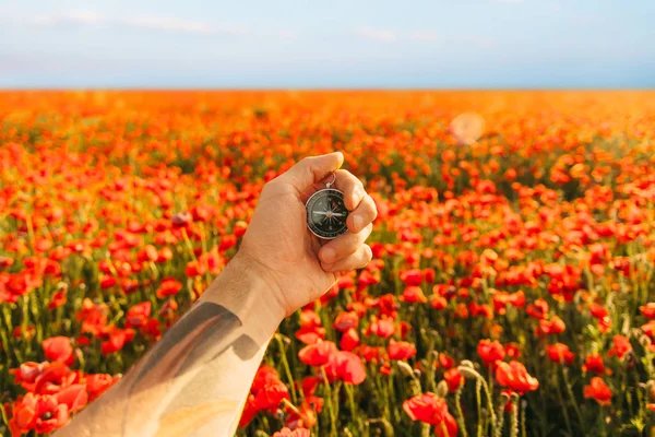 Viaje Brújula Magnética Una Mano Masculina Fondo Pradera Amapolas Rojas —  Fotos de Stock