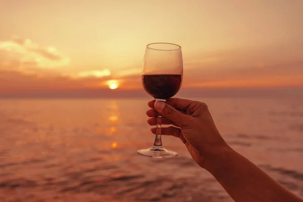 Mão Feminina Com Copo Com Vinho Tinto Fundo Mar Pôr — Fotografia de Stock