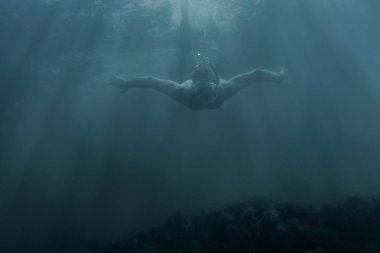 Maske sualtı arasında güneş ışınları, önden görünüm yüzme içinde aktif erkek freediver.