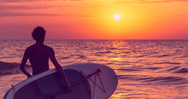 Unbekannter Junger Mann Mit Surfbrett Geht Bei Sonnenuntergang Ans Meer — Stockfoto