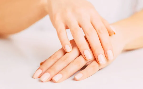 Manos femeninas con manicura beige . — Foto de Stock