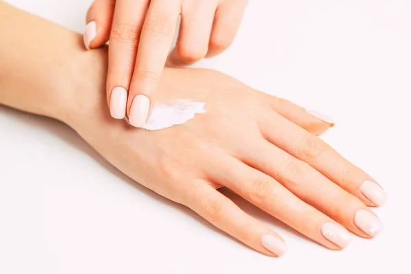 Las manos de la mujer aplicando crema hidratante para el cuidado de la piel . — Foto de Stock