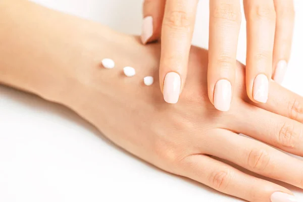 Vrouwelijke handen toepassing hydraterende crème voor gladde huid. — Stockfoto