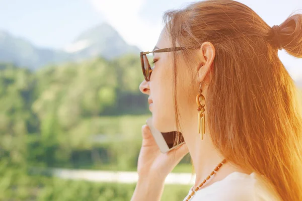 Žena mluví na telefonu na pozadí letních hor. — Stock fotografie