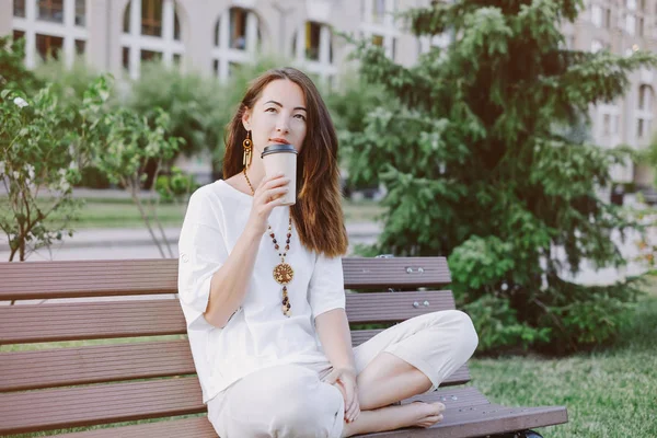 Mujer soñadora sentada con una taza de café en el parque de verano . —  Fotos de Stock