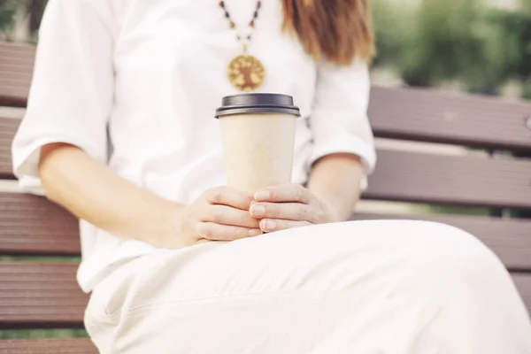 Onherkenbaar vrouw zitten met take-away papier kopje koffie. — Stockfoto