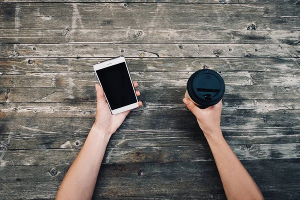 Mani femminili con smartphone e tazza da asporto di caffè, punto di vista . — Foto Stock