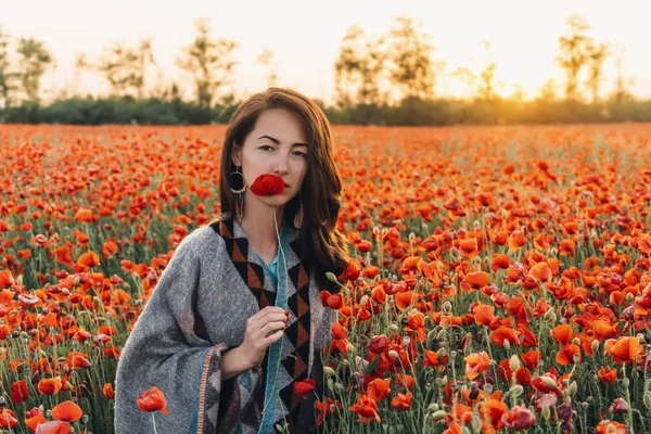 Όμορφη νεαρή γυναίκα με κόκκινη παπαρούνα στο λιβάδι λουλουδιών. — Φωτογραφία Αρχείου